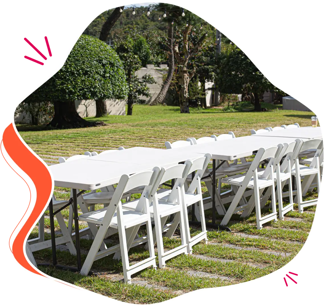 White folding chairs and tables outdoors.