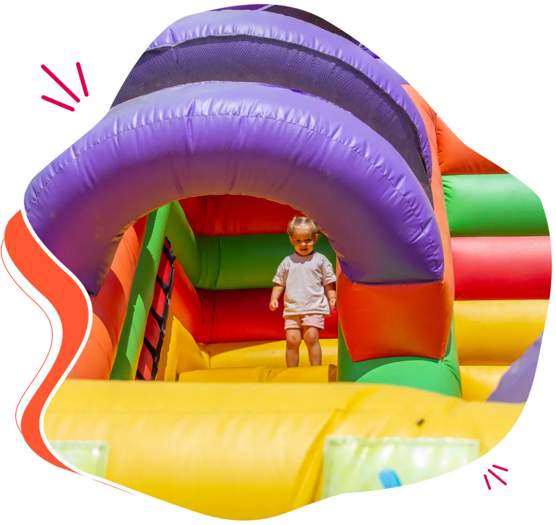 Toddler playing in colorful inflatable bounce house.