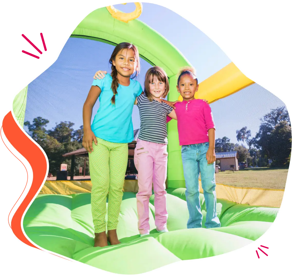 Three girls hugging in a bouncy castle.